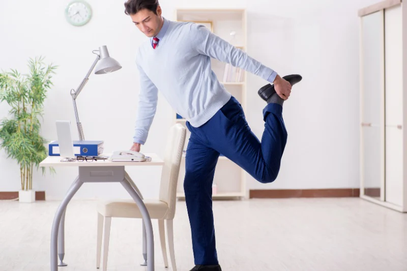 Person performing a simple standing stretch at a desk workspace